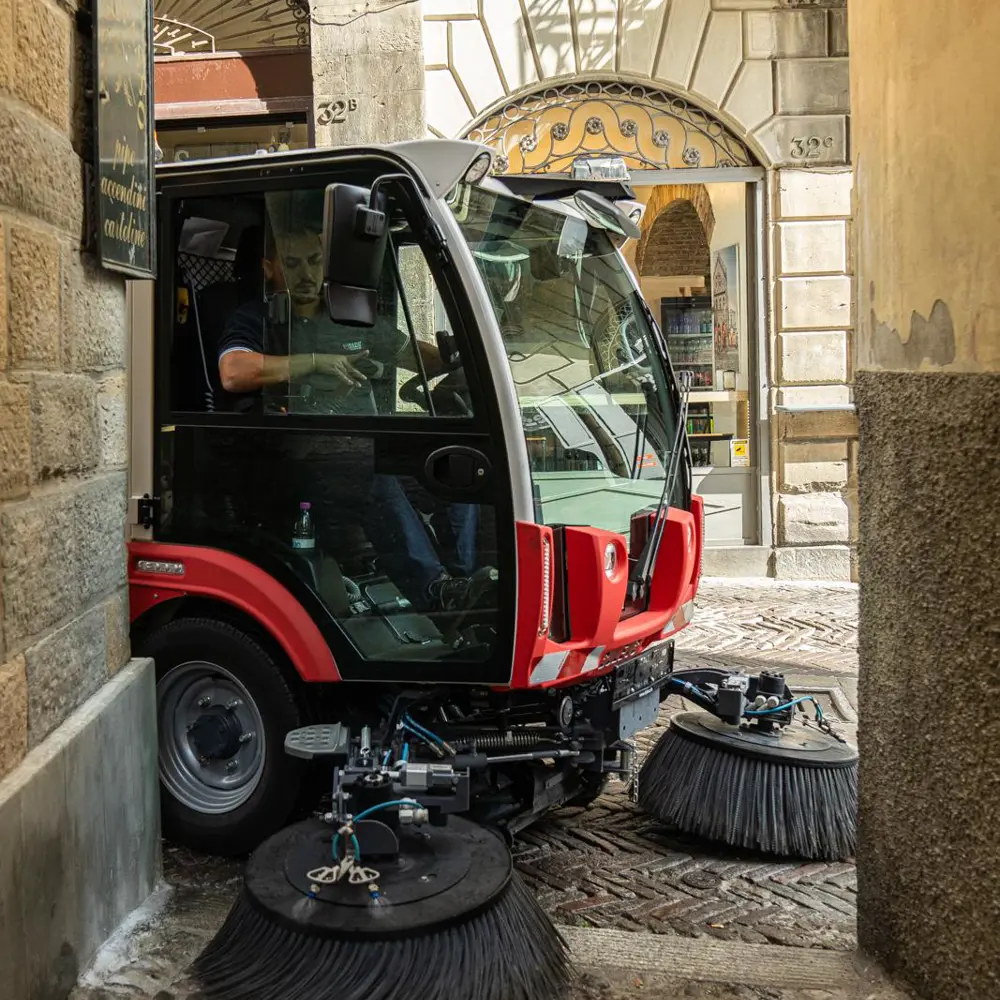 Dulevo Dzero2 compacte straatveegmachine manoeuvreert door smal straatje in binnenstad