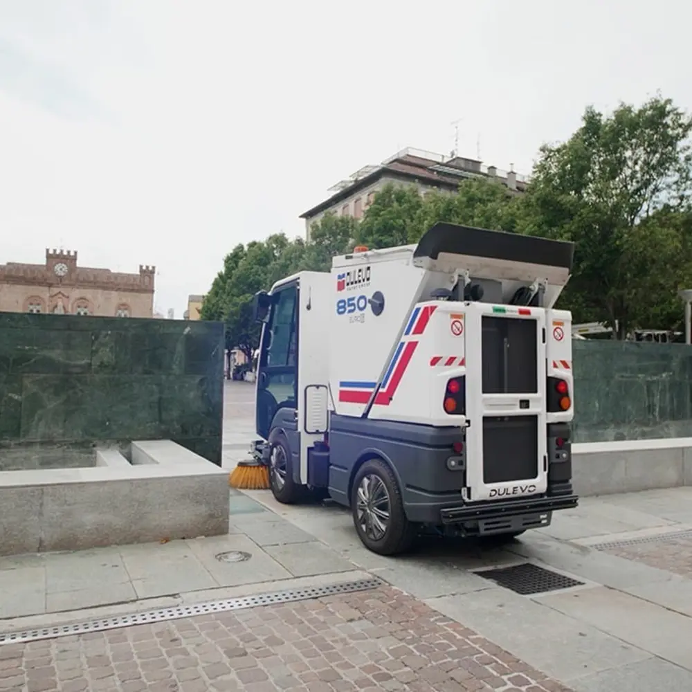Dulevo 850 veegwagen op stadsplein naast historisch gebouw, compacte straatveegmachine achteraanzicht