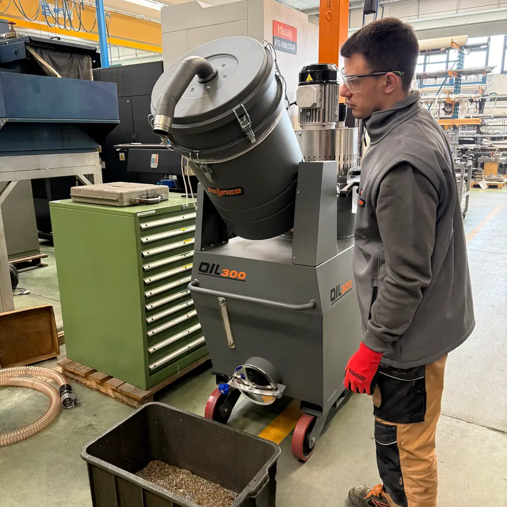 Medewerker leegt metaalspanen uit Coynco OIL 300 oliezuiger in opvangbak