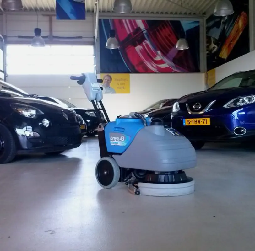 Industriële schrobzuigmachine achterloper bij HV auto in de showroom