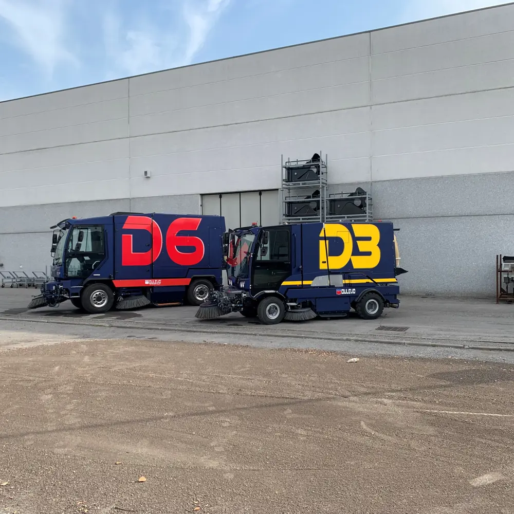 Dulevo D6 en D3 straatveegmachines naast elkaar bij bedrijfspand