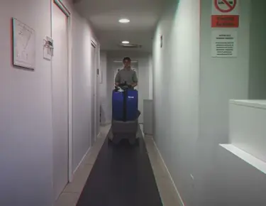 Floorpul schrobmachine reinigt smalle gang in kantoorgebouw in Nederland