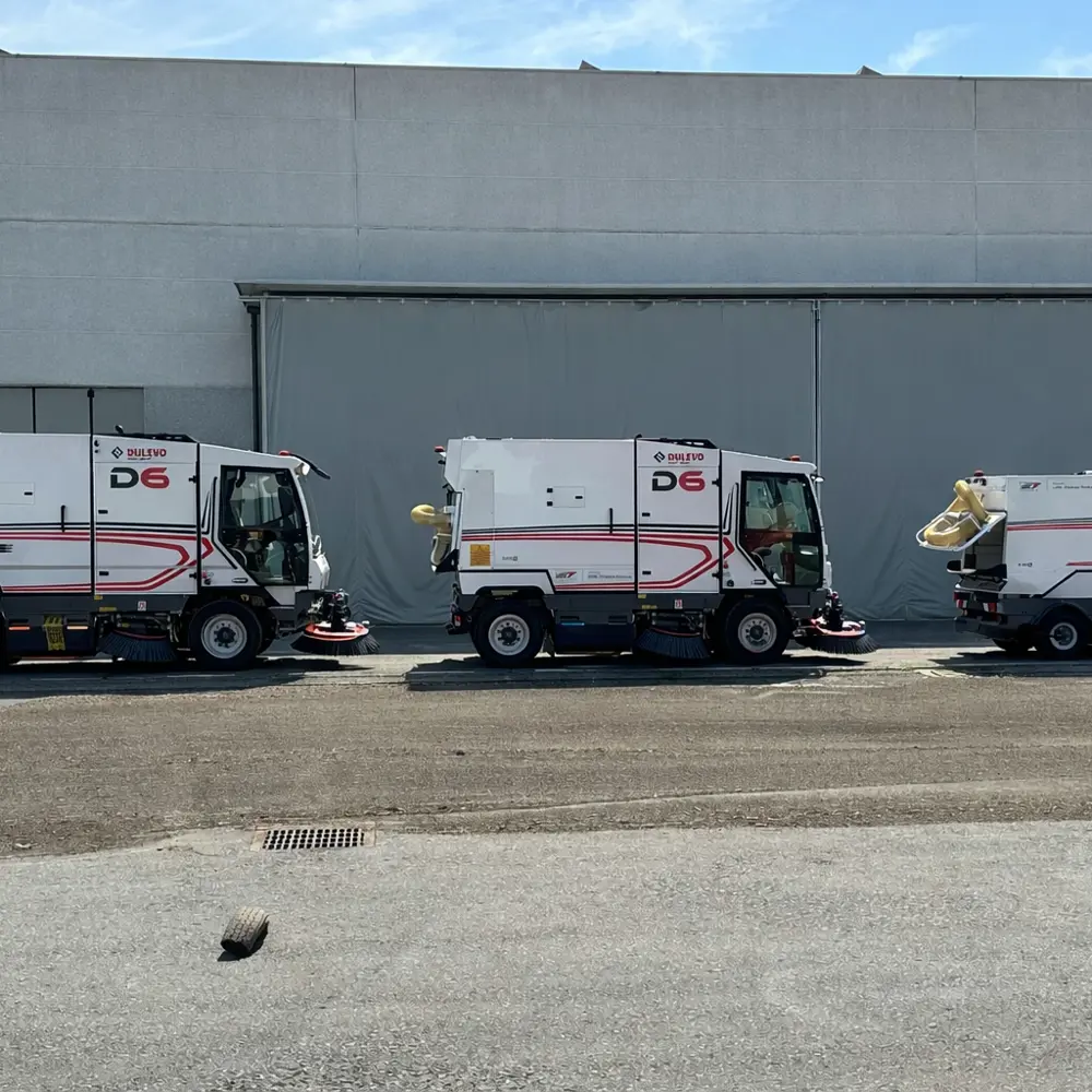 Drie Dulevo veegmachines waaronder twee D6 modellen opgesteld bij een loods