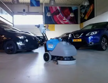 Industriële schrobzuigmachine achterloper bij HV auto in de showroom