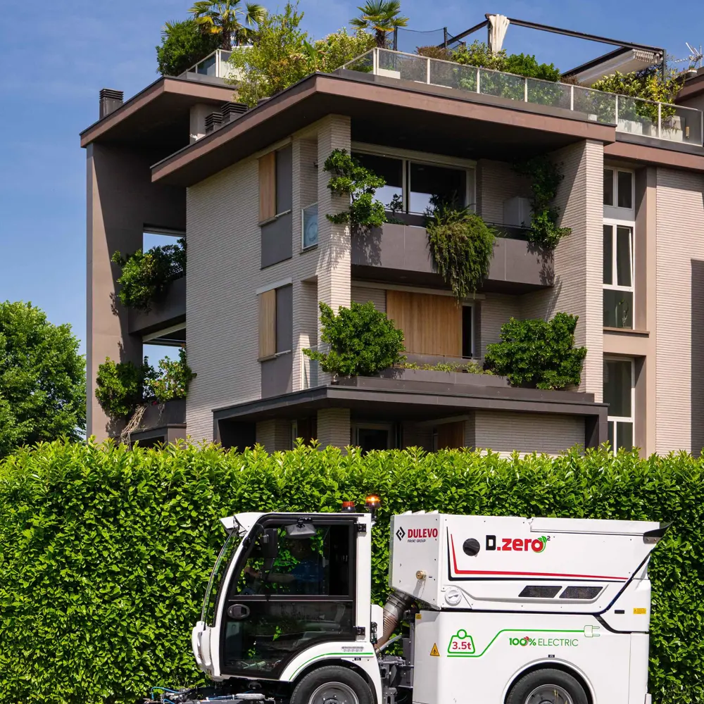 Elektrische straatveegmachine Dulevo Dzero2 veegt stoep in woonwijk in Nederland