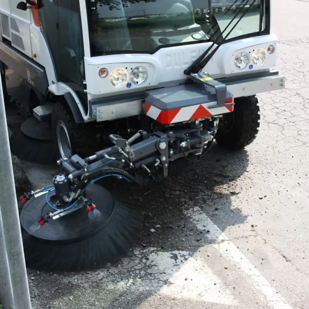 Voorborstel van Dulevo veegmachine in actie langs stoeprand en straat