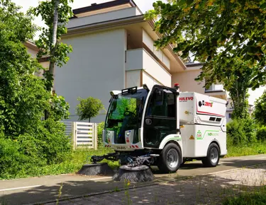 Dulevo Dzero2 elektrische veegwagen reinigt straat in groene woonwijk