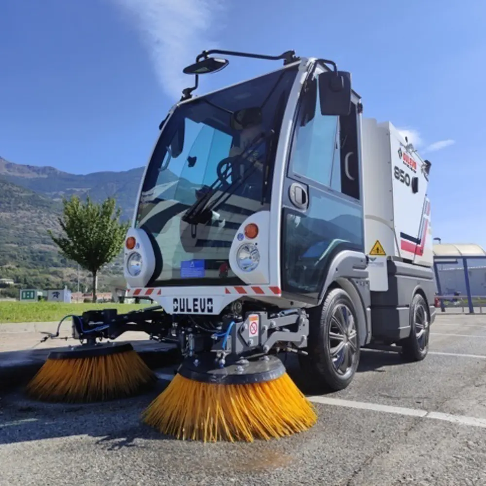Dulevo 850 straatveegmachine frontaal met twee oranje borstels, compacte veegwagen op parkeerterrein
