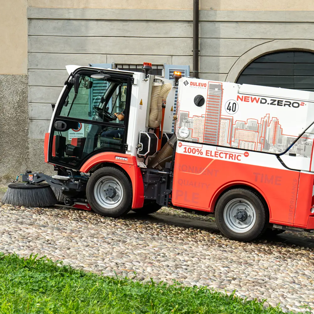 Compacte elektrische veegwagen Dulevo Dzero2 geparkeerd naast een historisch pand