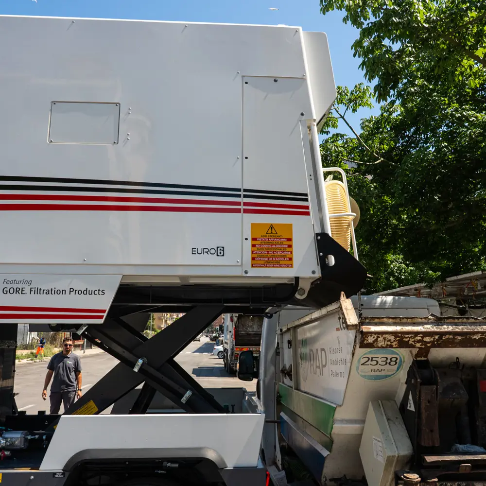 Dulevo D6 met opgeheven vuilcontainer voor het legen van veegvuil