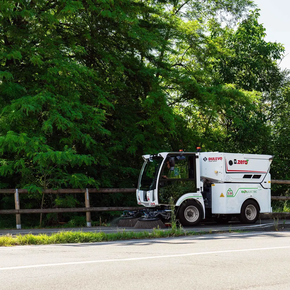 Dulevo Dzero2 emissievrije straatveegmachine rijdt langs bosrijke weg