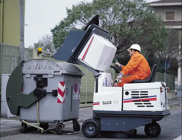 De veegmachine Dulevo 1300 dumpt zijn vuil in een rolcontainer